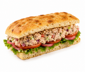 Tuna sandwich with creamy tuna salad, fresh ciabatta bread, lettuce, tomatoes, and pickled onions